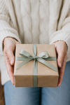 Hands presenting a carefully wrapped gift.